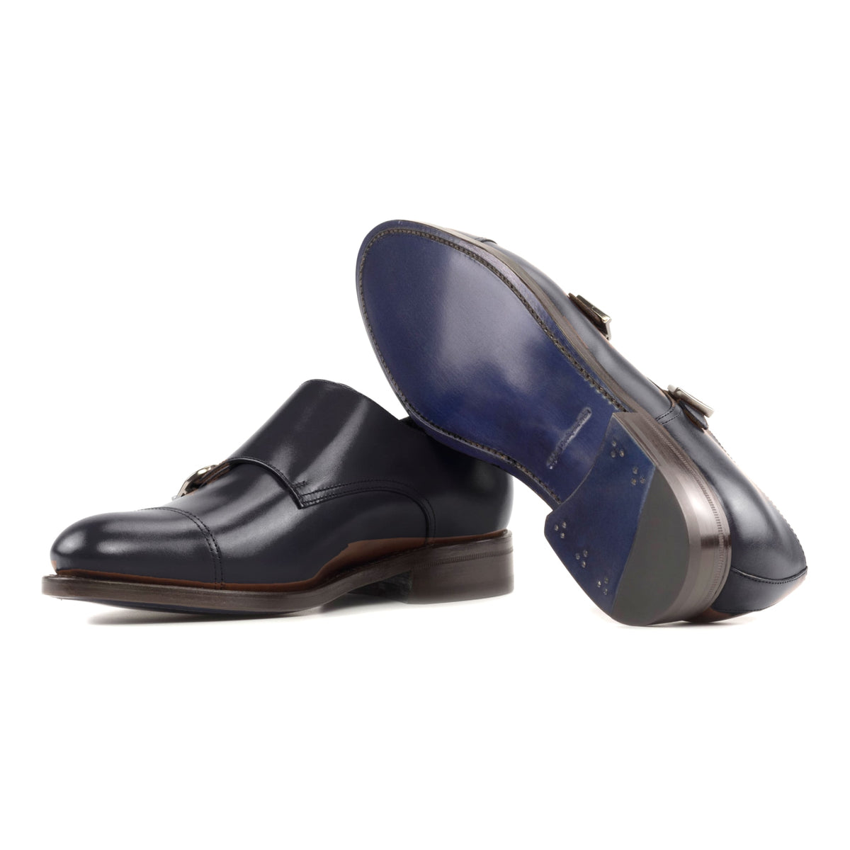 Chaussure double boucle en cuir bleu marine : une chaussure debout, l’autre couchée montre sa semelle