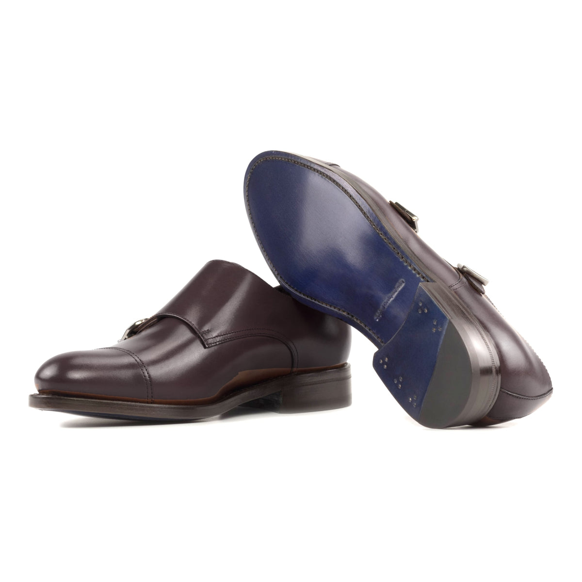 Chaussure double boucle en cuir bordeaux : une chaussure debout, l’autre couchée montre sa semelle