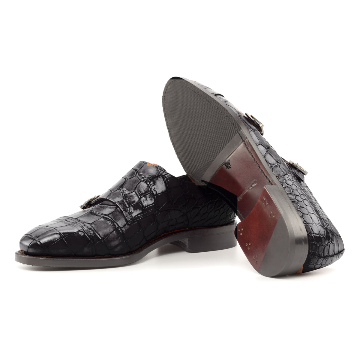 Chaussure double boucle en cuir croco noir : une chaussure debout, l’autre couchée montre sa semelle