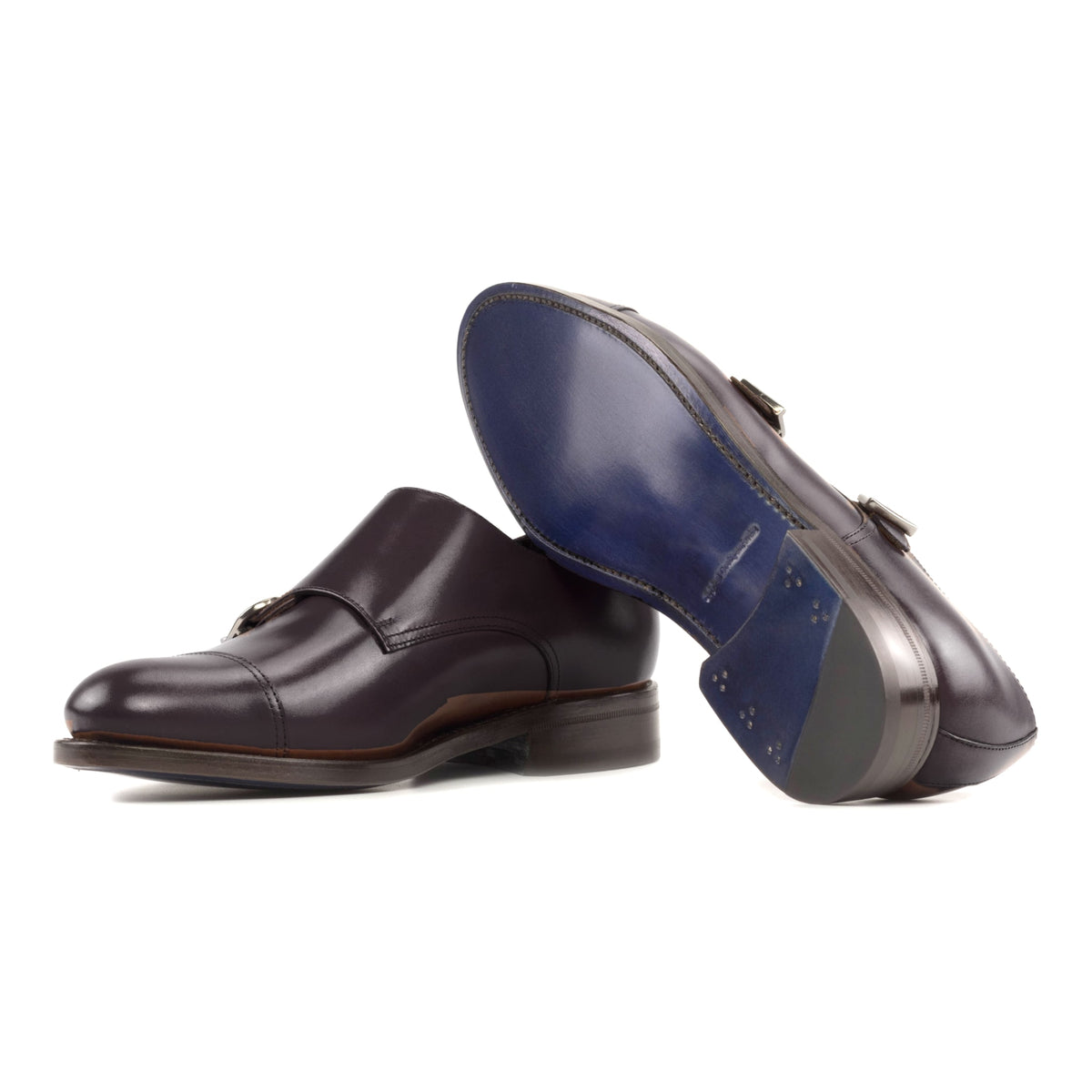 Chaussure double boucle en cuir sang-de-bœuf : une chaussure debout, l’autre couchée montre sa semelle