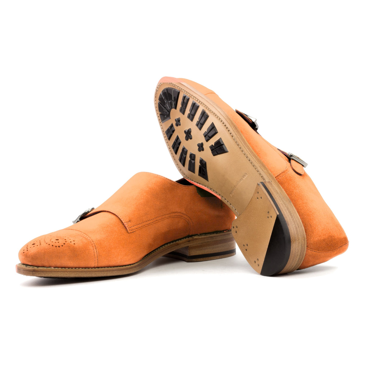 Chaussure double boucle en daim de chevreau orange : une chaussure debout, l’autre couchée montre sa semelle