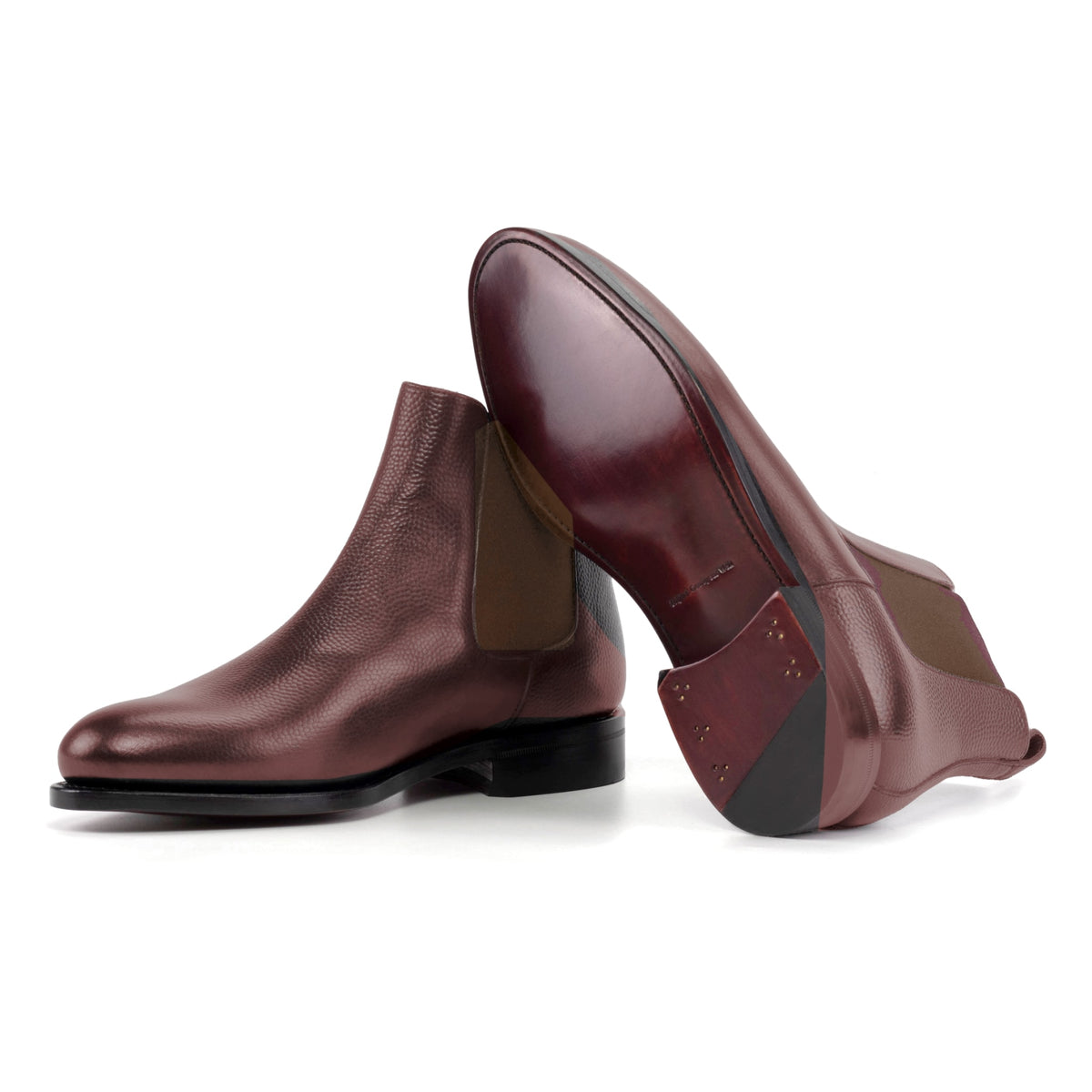 Chelsea Boots en cuir grainé bordeaux, semelle cuir : une bottine debout, l’autre couchée montre sa semelle