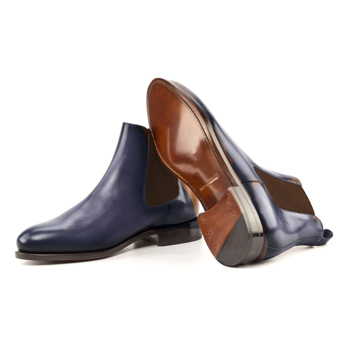 Chelsea Boots en cuir teinté main bleu pétrole, semelle cuir : une bottine debout, l’autre couchée montre sa semelle