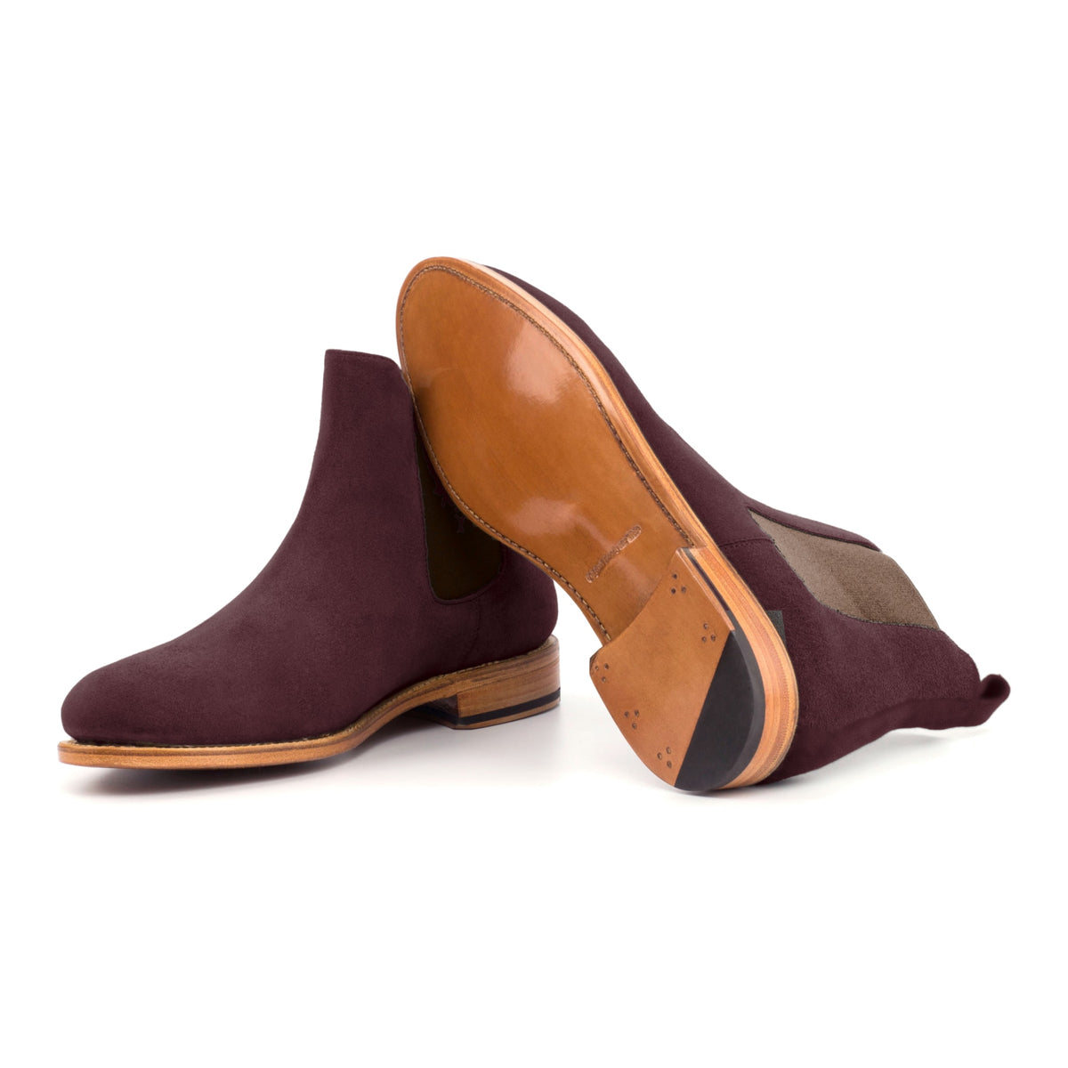 Chelsea Boots en daim bordeaux, semelle cuir : une bottine debout, l’autre couchée montre sa semelle
