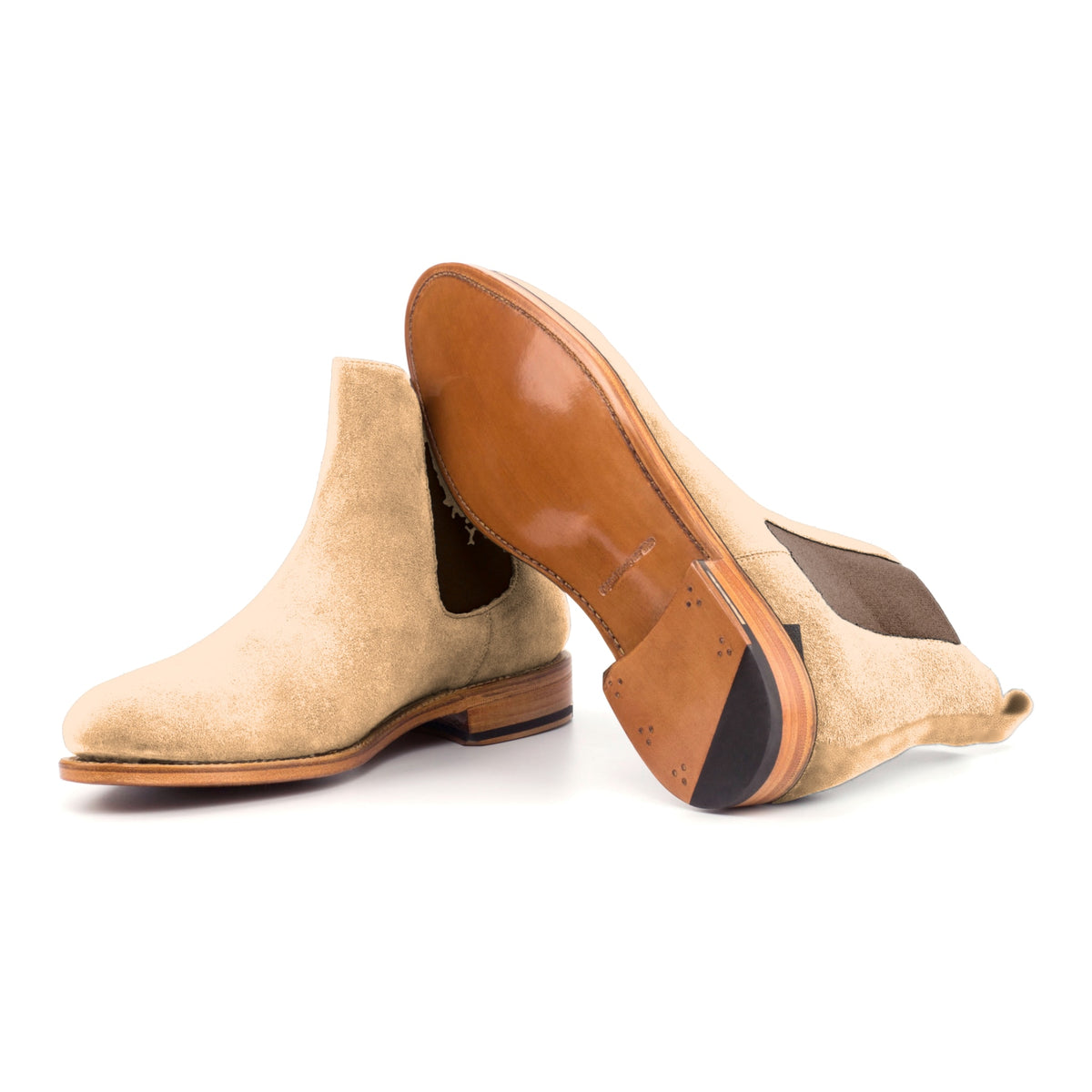 Chelsea Boots en daim de chevreau camel, semelle cuir : une bottine debout, l’autre couchée montre sa semelle