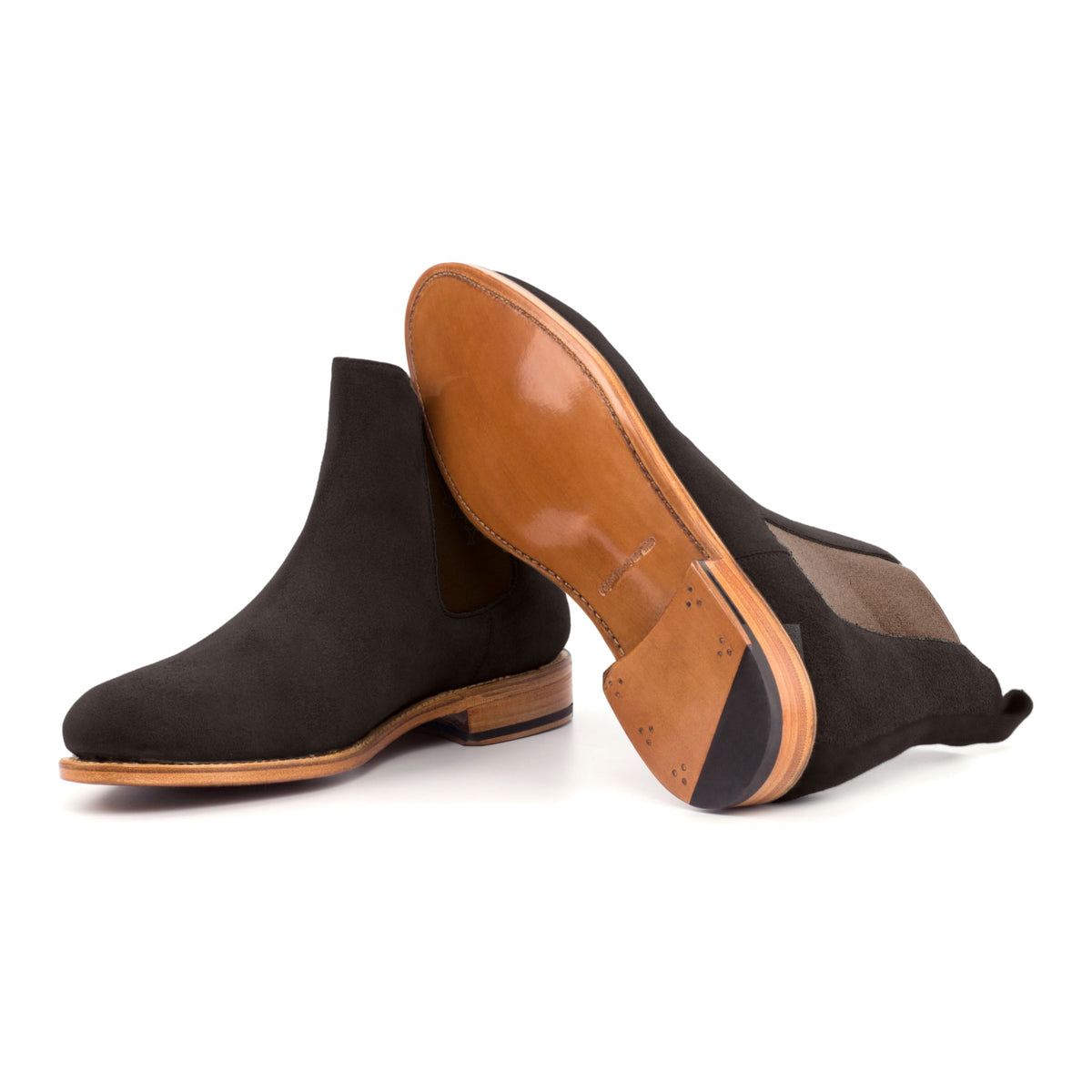 Chelsea Boots en daim marron foncé, semelle cuir : une bottine debout, l’autre couchée montre sa semelle