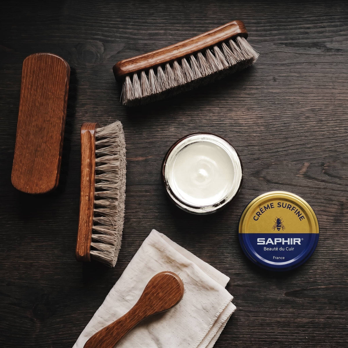 Crème Surfine Saphir Coquille d'Œuf en pot ouvert, avec des brosses en crin et une chamoisine, vue de dessus
