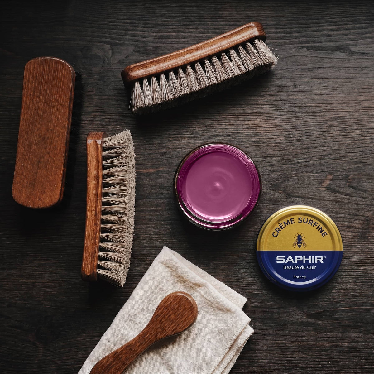 Crème Surfine Saphir Lavande en pot ouvert, avec des brosses en crin et une chamoisine, vue de dessus