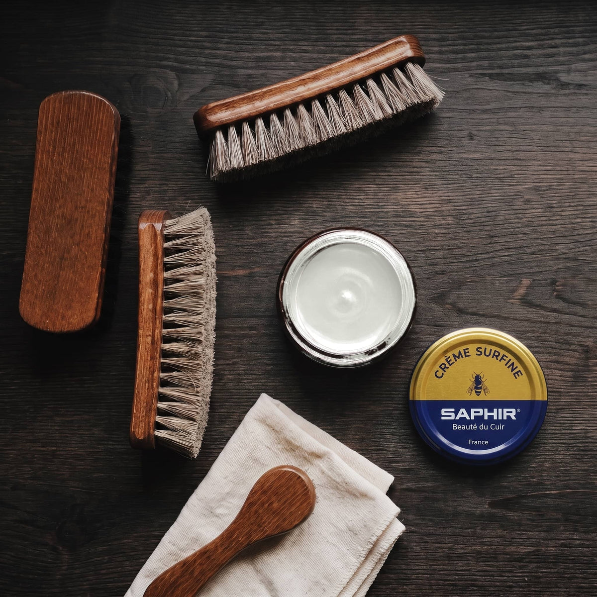 Crème Surfine Saphir Marbre en pot ouvert, avec des brosses en crin et une chamoisine, vue de dessus