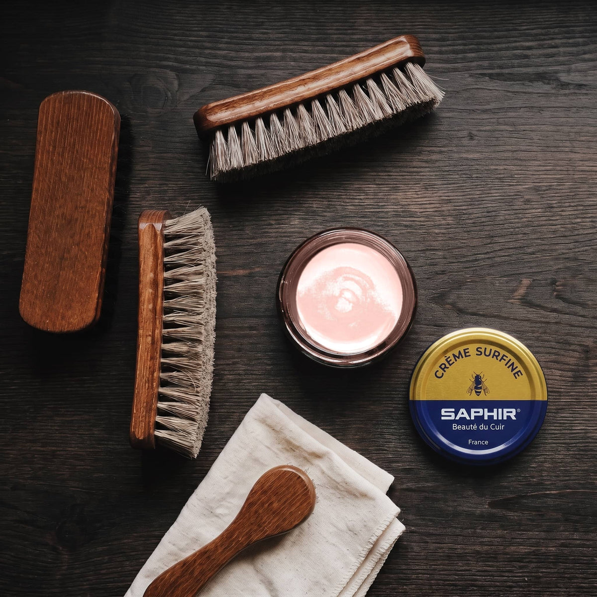 Crème Surfine Saphir Rose en pot ouvert, avec des brosses en crin et une chamoisine, vue de dessus