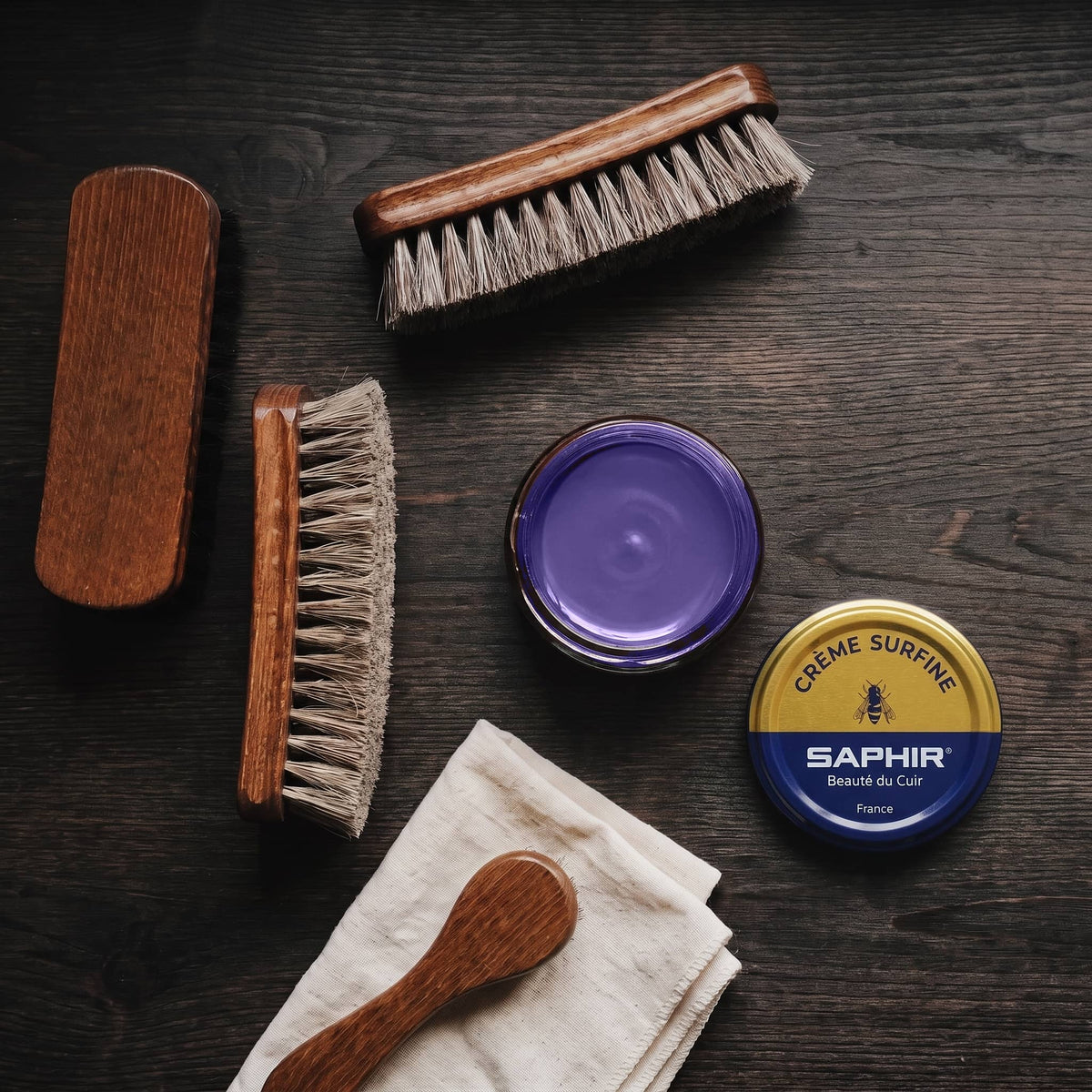Crème Surfine Saphir Violet en pot ouvert, avec des brosses en crin et une chamoisine, vue de dessus