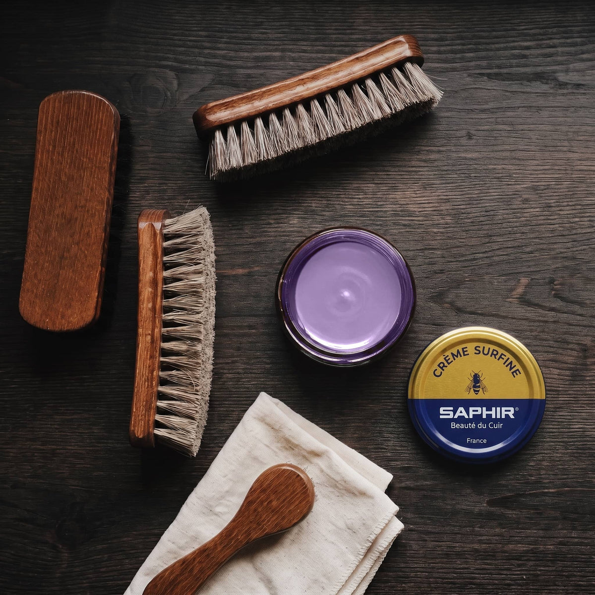 Crème Surfine Saphir Violine en pot ouvert, avec des brosses en crin et une chamoisine, vue de dessus