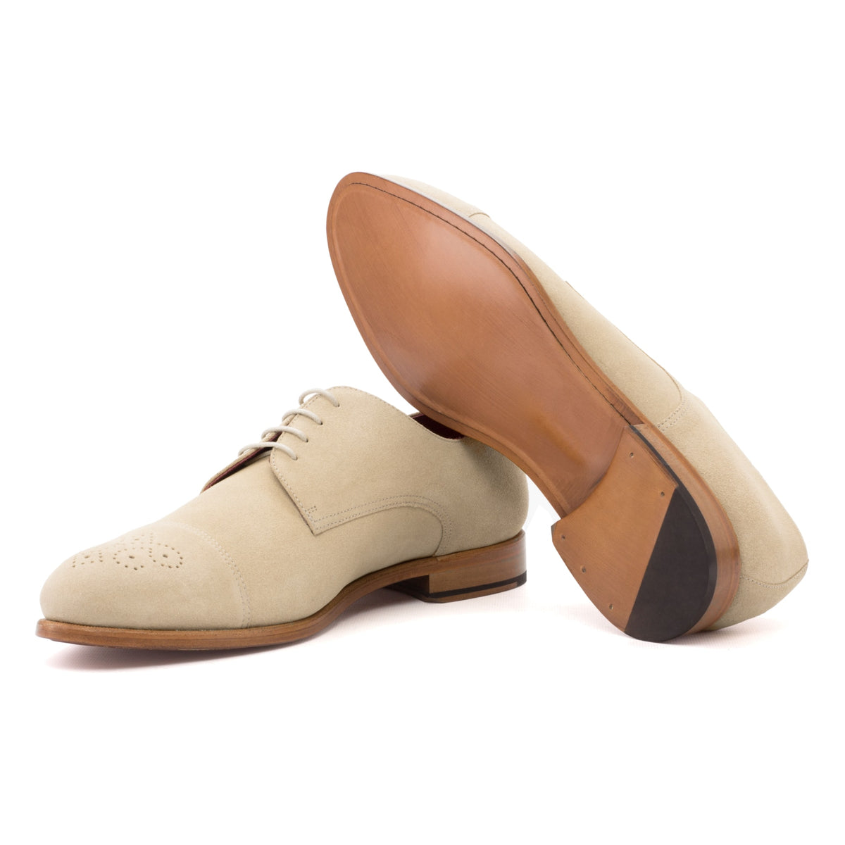 Derby bout droit fleuri en daim de chevreau beige, semelle cuir : une chaussure debout, l’autre couchée montre sa semelle