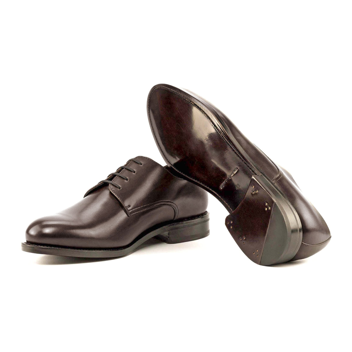 Derby en cuir marron moyen, semelle cuir : une chaussure debout, l’autre couchée montre sa semelle