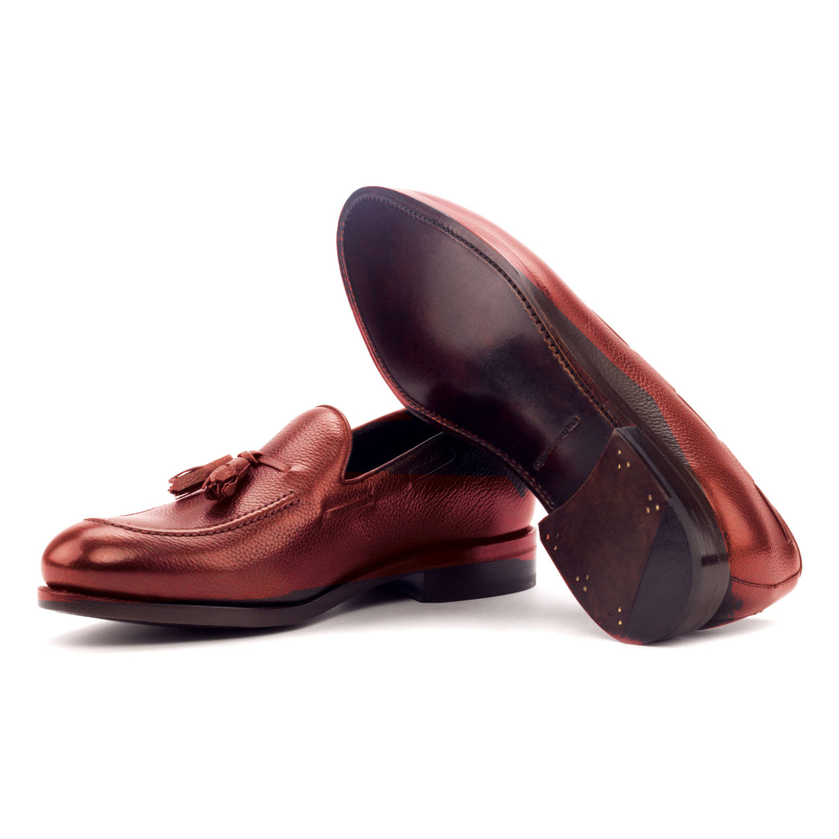Mocassin à glands en cuir grainé rouge : une chaussure couchée montre la semelle