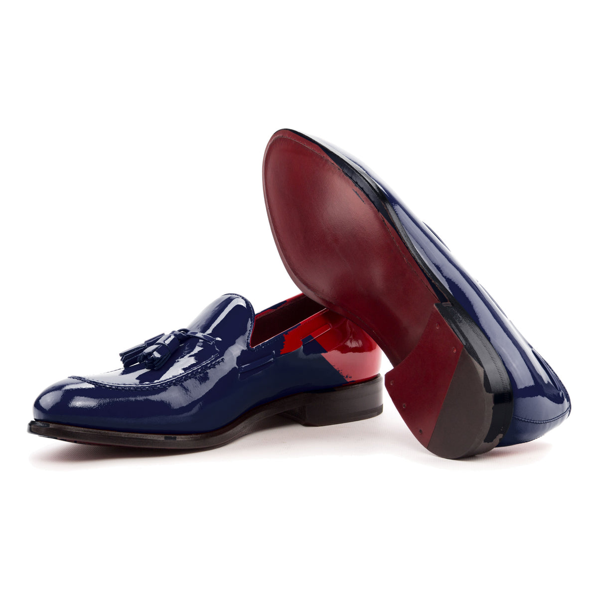 Mocassin à glands en cuir vernis bleu marine : une chaussure couchée montre la semelle