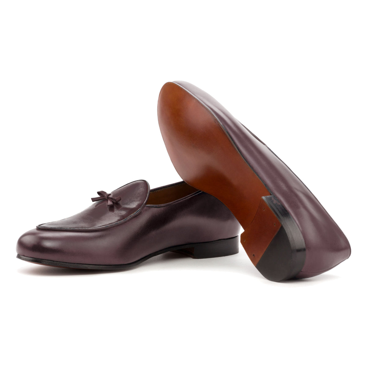 Mocassin belge en cuir teinté main bordeaux : une chaussure couchée montre la semelle