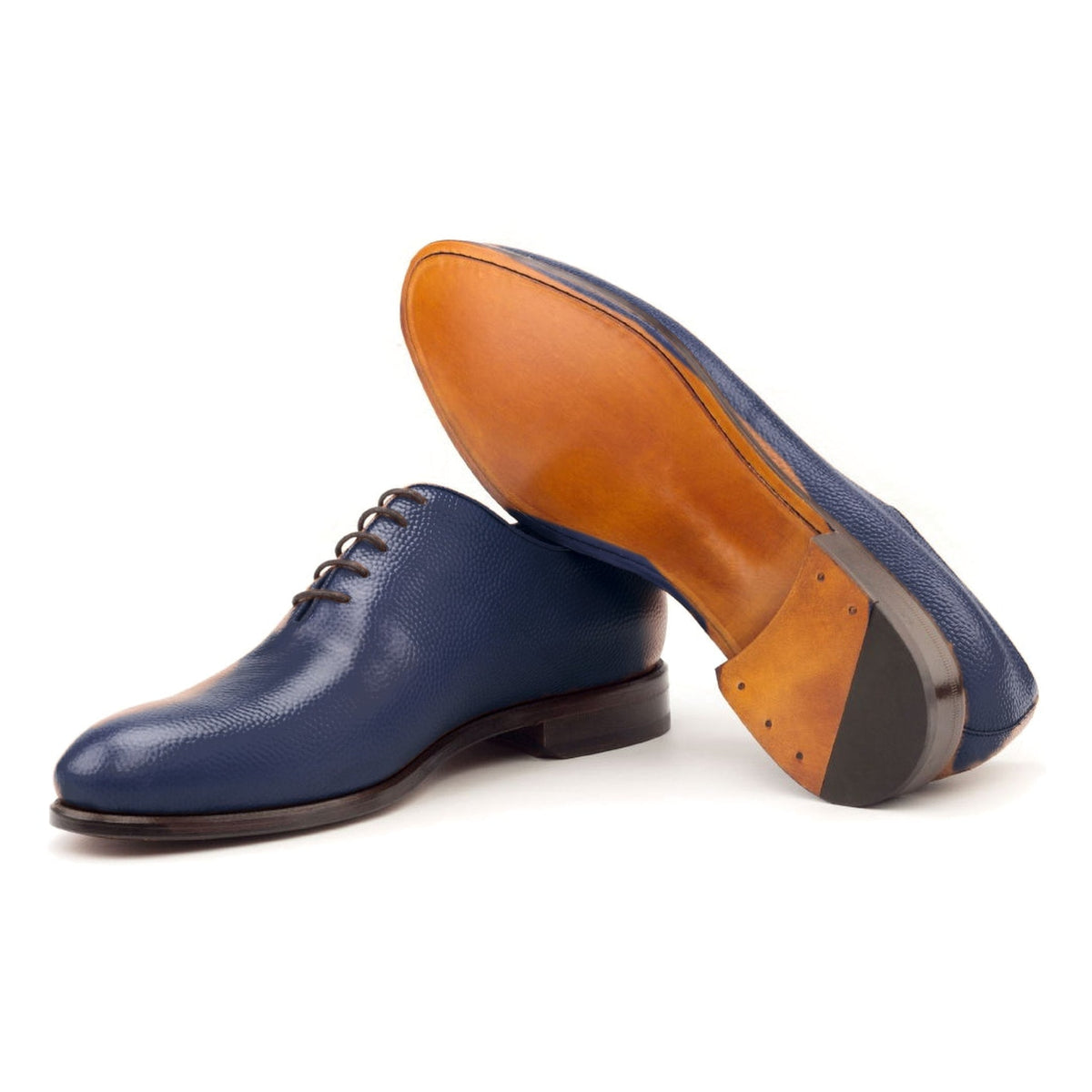 One Cut en cuir gros grain bleu pétrole, semelle cuir : une chaussure debout, l’autre couchée montre sa semelle