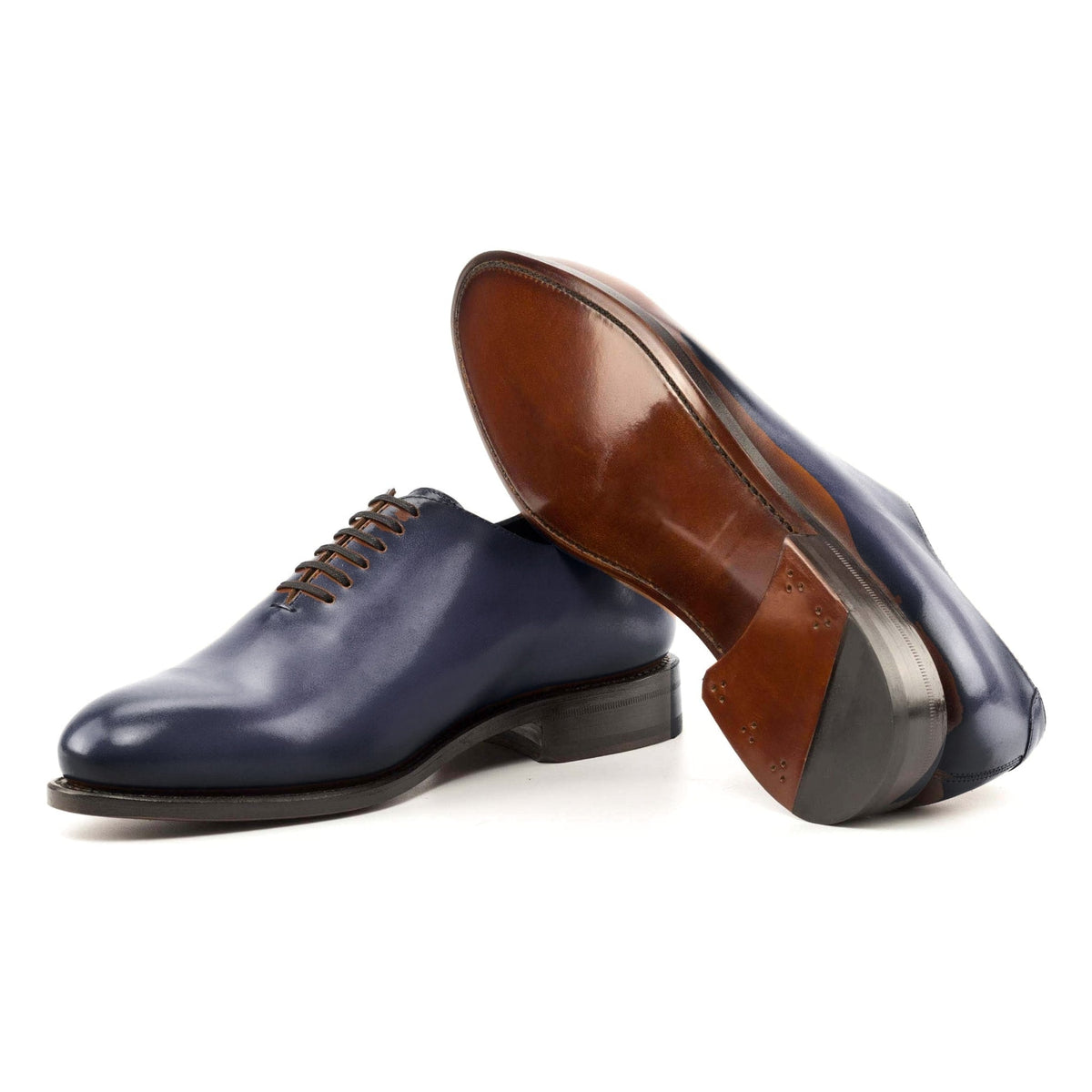 One Cut en cuir teinté main bleu pétrole, semelle cuir : une chaussure debout, l’autre couchée montre sa semelle