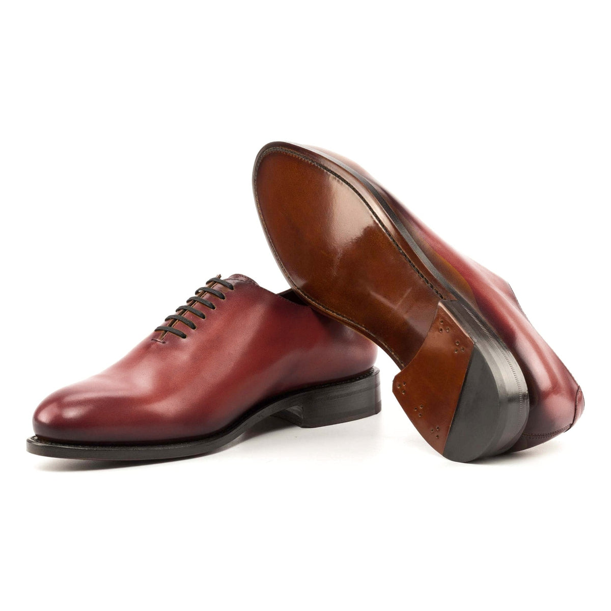 One Cut en cuir teinté main rouge, semelle cuir : une chaussure debout, l’autre couchée montre sa semelle