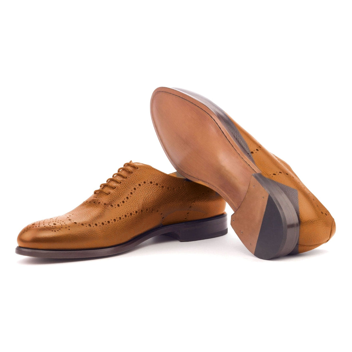 One Cut perforé en cuir grainé cognac, semelle cuir : une chaussure debout, l’autre couchée montre sa semelle
