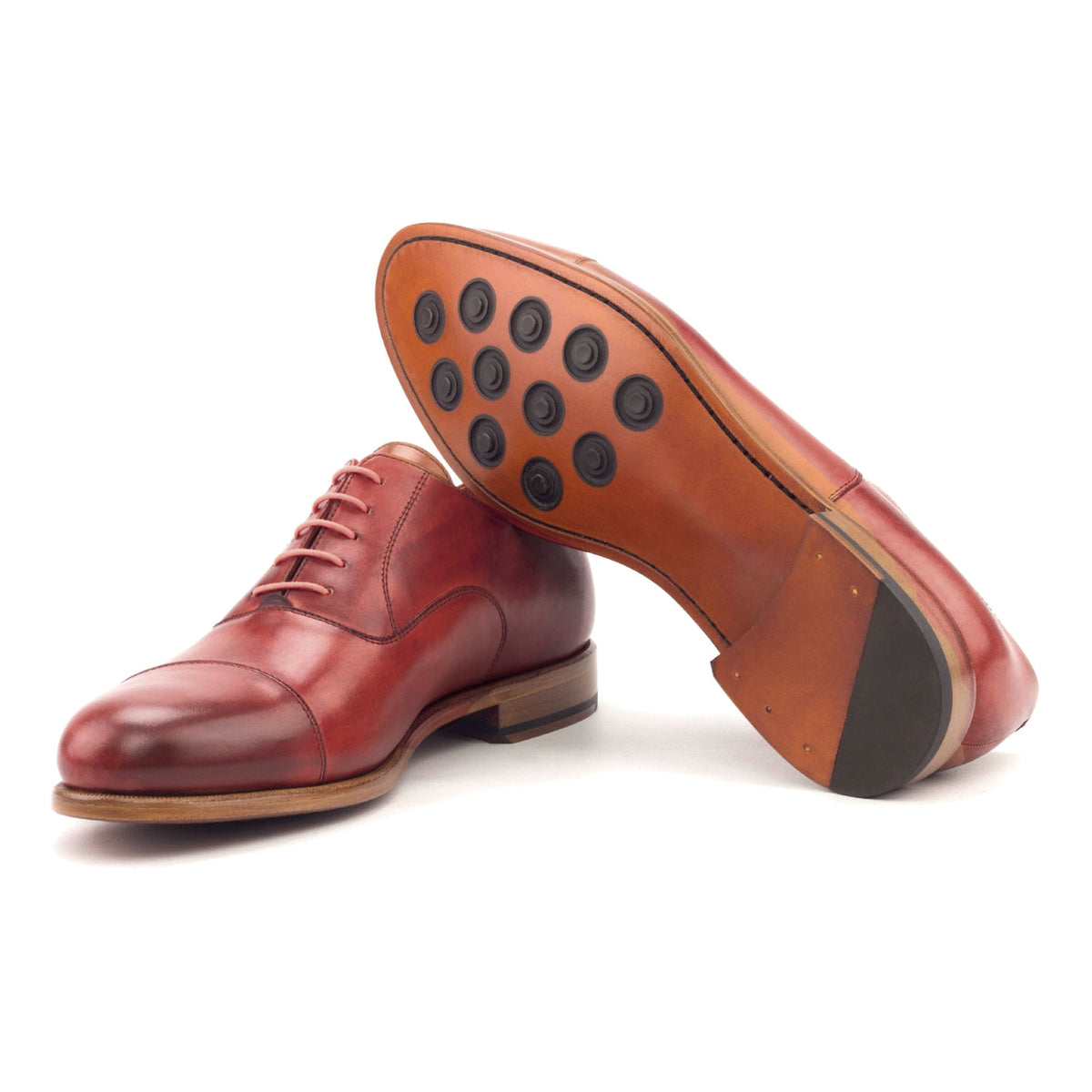 Richelieu bout droit en cuir teinté main rouge, semelle cuir Buttons : une chaussure debout, l’autre couchée montre sa semelle
