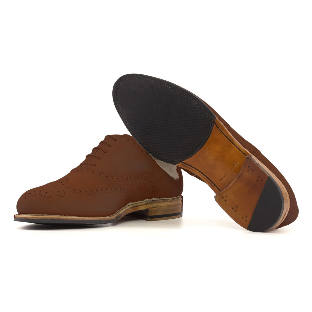 Richelieu fleuri en daim marron moyen, semelle cuir et patin : une chaussure debout, l’autre couchée montre sa semelle